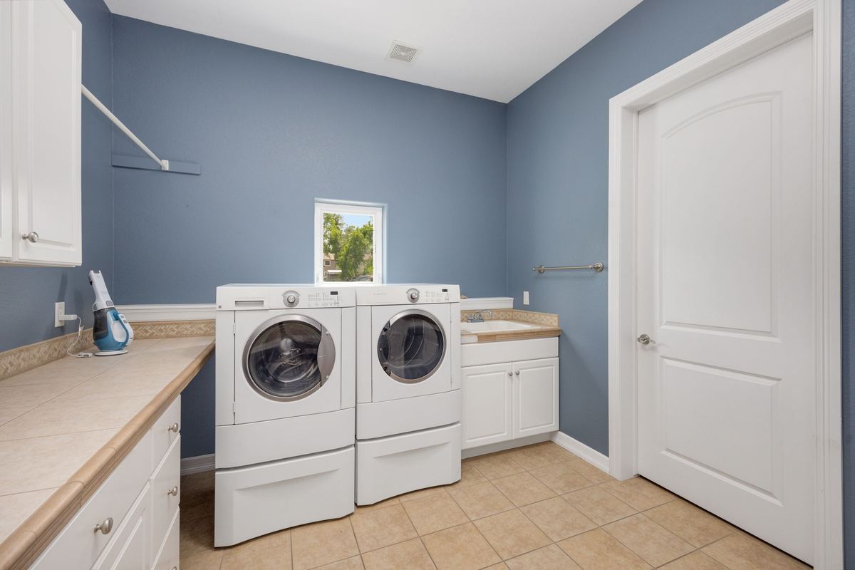 White washing machine and tumble dryer side by side in a laundry room