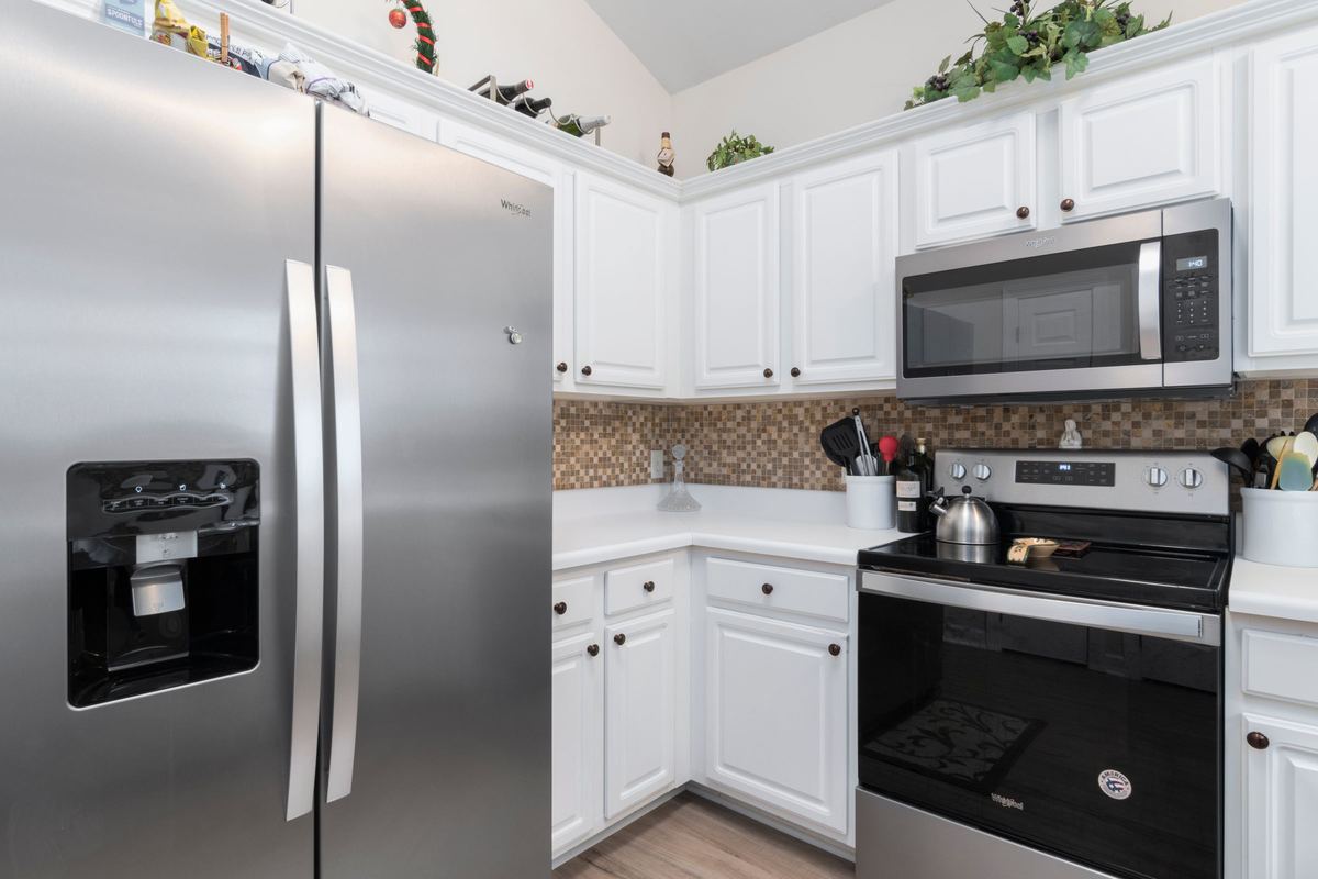 Stainless steel side-by-side fridge in a white kitchen