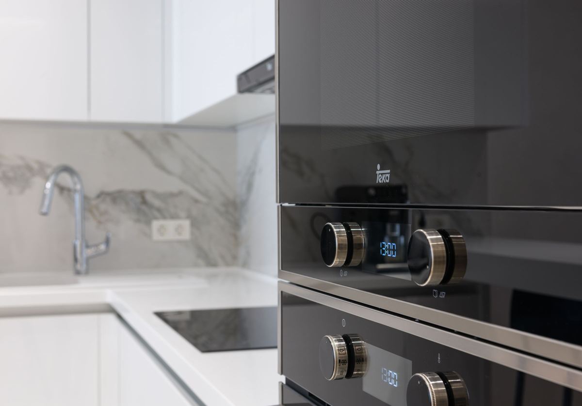 Built-in electric ovens with control knobs in a modern kitchen