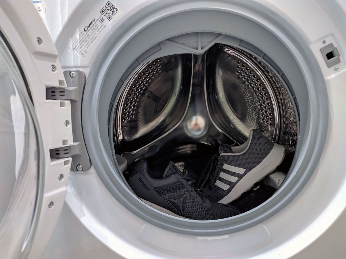Open front-loading washing machine showing the stainless steel drum